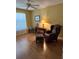 Bright living room featuring a chair, lamp, and ceiling fan at 3183 Hatch Ln, The Villages, FL 32162