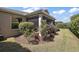 Landscaped backyard with screened lanai featuring vibrant plants and lush lawn at 3186 Killington Loop, The Villages, FL 32163