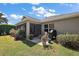 Backyard view with screened lanai, lush landscaping, and outdoor seating area at 3186 Killington Loop, The Villages, FL 32163