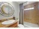 Bathroom featuring tub and shower, decorative mirror and natural-tone tile at 3186 Killington Loop, The Villages, FL 32163