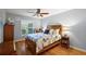 Bedroom featuring hardwood floors, ceiling fan, and window with plantation shutters at 3186 Killington Loop, The Villages, FL 32163