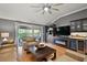 Bright living room featuring a modern ceiling fan, hardwood floors, and a built-in entertainment center at 3186 Killington Loop, The Villages, FL 32163