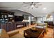 Spacious living room with hardwood floors, a modern ceiling fan, fireplace, and built-in shelving at 3186 Killington Loop, The Villages, FL 32163