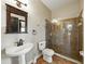 Bathroom featuring a glass shower, sink, toilet, and dark wood mirror with sconce lighting at 3234 Cypress Grove Dr, Eustis, FL 32736