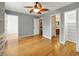 The bright bedroom features wood floors and a ceiling fan, as well as access to a closet and bathroom at 3234 Cypress Grove Dr, Eustis, FL 32736