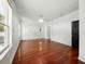 Spacious bedroom with hardwood floors, natural light, and access to hallway at 3234 Cypress Grove Dr, Eustis, FL 32736