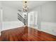 Dining room with hardwood floors, chandelier, wainscoting, and staircase in the background at 3234 Cypress Grove Dr, Eustis, FL 32736