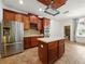 Kitchen featuring custom cabinets, stainless steel refrigerator, island, and tiled flooring at 3234 Cypress Grove Dr, Eustis, FL 32736