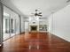 Open living room with hardwood floors, fireplace, built-in shelving, and sliding glass doors to patio at 3234 Cypress Grove Dr, Eustis, FL 32736