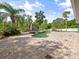 Inviting pool area with a stone patio, lush landscaping, and outdoor fireplace at 3234 Cypress Grove Dr, Eustis, FL 32736
