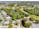 Aerial view of a community featuring a golf course, ponds and mature landscaping at 32800 Oak Park Dr, Leesburg, FL 34748