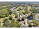 Wide aerial view of a residential community with lush greenery, serene ponds, and a golf course at 32800 Oak Park Dr, Leesburg, FL 34748