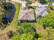 Aerial view of a single-Gathering home situated on a pond with mature trees and a well-manicured lawn at 32800 Oak Park Dr, Leesburg, FL 34748