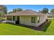 Back exterior view of a home with well maintained lawn and large windows at 32800 Oak Park Dr, Leesburg, FL 34748