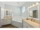 Luxurious bathroom featuring a soaking tub, vanity with sinks, and ample lighting at 32800 Oak Park Dr, Leesburg, FL 34748