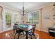 Dining room with hardwood floors, charming chandelier, and views of the backyard through large windows and french doors at 32800 Oak Park Dr, Leesburg, FL 34748