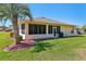 Backyard view of home, showcasing the enclosed lanai, lush lawn, and attractive landscaping at 32800 Oak Park Dr, Leesburg, FL 34748