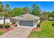 Charming home featuring an inviting entryway, two-car garage, mature trees, and beautiful landscaping at 32800 Oak Park Dr, Leesburg, FL 34748