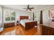 Hardwood floors, neutral paint, large window, and french doors in the main bedroom at 32800 Oak Park Dr, Leesburg, FL 34748