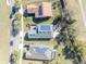 Aerial view showing rooftops with solar panels, landscaped yards, and a paver patio, amidst tree-lined streets at 341 Silver Maple Rd, Groveland, FL 34736