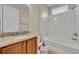 Bathroom featuring a granite vanity, bath tub with white tile, and decorative toilet at 341 Silver Maple Rd, Groveland, FL 34736