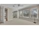 Bedroom with neutral carpet, ceiling fan, three windows, and light beige paint at 341 Silver Maple Rd, Groveland, FL 34736