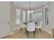 Cozy breakfast nook featuring bright windows, a modern chandelier, and a round dining table with seating for four at 341 Silver Maple Rd, Groveland, FL 34736