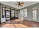 Bright sun room with hardwood floors, modern ceiling fan, and large windows for natural light at 341 Silver Maple Rd, Groveland, FL 34736