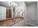 Bright bathroom featuring white cabinets, beige countertop, decorative mirror, and shower with curtain at 3655 Idlewood Loop, The Villages, FL 32162