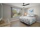 Bedroom featuring a window view, ceiling fan, neutral color palette, and patterned bed linens at 3655 Idlewood Loop, The Villages, FL 32162