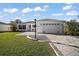 Charming one-story home showcasing manicured landscaping and a welcoming, paved driveway leading to the garage at 3655 Idlewood Loop, The Villages, FL 32162