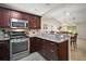 Well-equipped kitchen featuring stainless steel appliances, granite countertops, and rich wood cabinetry at 3655 Idlewood Loop, The Villages, FL 32162