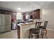 Kitchen with stainless steel appliances, granite countertops, a breakfast bar and dark-stained wood cabinets at 3655 Idlewood Loop, The Villages, FL 32162