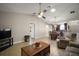 Bright living room featuring tile floors, a ceiling fan, and an open view into the dining and kitchen area at 3655 Idlewood Loop, The Villages, FL 32162