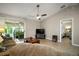 Open-concept living room with sliding doors to sunroom, ceiling fan, and tile flooring at 3655 Idlewood Loop, The Villages, FL 32162