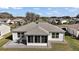 Rear exterior view featuring the home's well-maintained roof, screened lanai, and patio area with outdoor seating at 3655 Idlewood Loop, The Villages, FL 32162