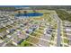 Aerial view showcasing 3719 Holly Grove Lane and the surrounding neighborhood with a distant lake at 3719 Holly Grove Ln, Mount Dora, FL 32757