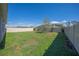 View of the spacious backyard featuring a well-maintained lawn, white fence, and mature tree at 3719 Holly Grove Ln, Mount Dora, FL 32757