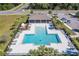 Aerial view of a community pool, featuring a uniquely shaped pool, lounge chairs, and a covered pavilion at 3719 Holly Grove Ln, Mount Dora, FL 32757