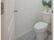 Small toilet room featuring a modern toilet with decorative plant, and a gray tile floor at 3719 Holly Grove Ln, Mount Dora, FL 32757