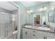 Light-filled bathroom featuring a double sink vanity, granite counters, and a glass-enclosed shower at 3786 Stephanie Way, The Villages, FL 32163