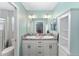 Light-filled bathroom featuring a double sink vanity, granite counters, and a glass-enclosed shower at 3786 Stephanie Way, The Villages, FL 32163