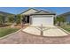 Patterned concrete driveway leading to a two-car garage, complemented by well-maintained landscaping and exterior at 3786 Stephanie Way, The Villages, FL 32163