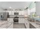 Well-lit kitchen featuring granite countertops, stainless appliances, and light wood flooring at 3786 Stephanie Way, The Villages, FL 32163