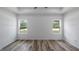 Well-lit bedroom with luxury vinyl flooring and white walls, featuring dual windows at 40691 E 9Th Ave, Umatilla, FL 32784