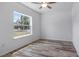 Bright bedroom with wood-look flooring, a window view and a ceiling fan for enhanced comfort at 40691 E 9Th Ave, Umatilla, FL 32784