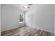 Bright bedroom with wood-look flooring, a window view and a ceiling fan for enhanced comfort at 40691 E 9Th Ave, Umatilla, FL 32784