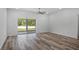 Bright living room featuring wood-look floors and sliding glass door, providing ample natural light at 40706 E Ninth Ave, Umatilla, FL 32784