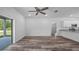 Open-concept living area with wood-look floors, white walls, and access to the covered patio at 40706 E Ninth Ave, Umatilla, FL 32784