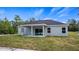 Rear exterior showcasing the home's covered patio and expansive backyard with lush grass at 40706 E Ninth Ave, Umatilla, FL 32784